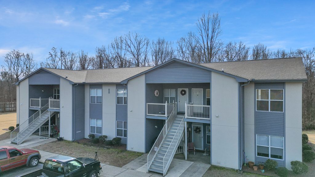 Apartment building exterior with staircases and landscaping